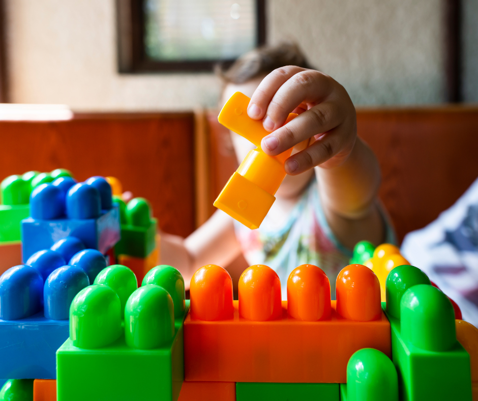 Kid with ADHD playing with multicolored blocks