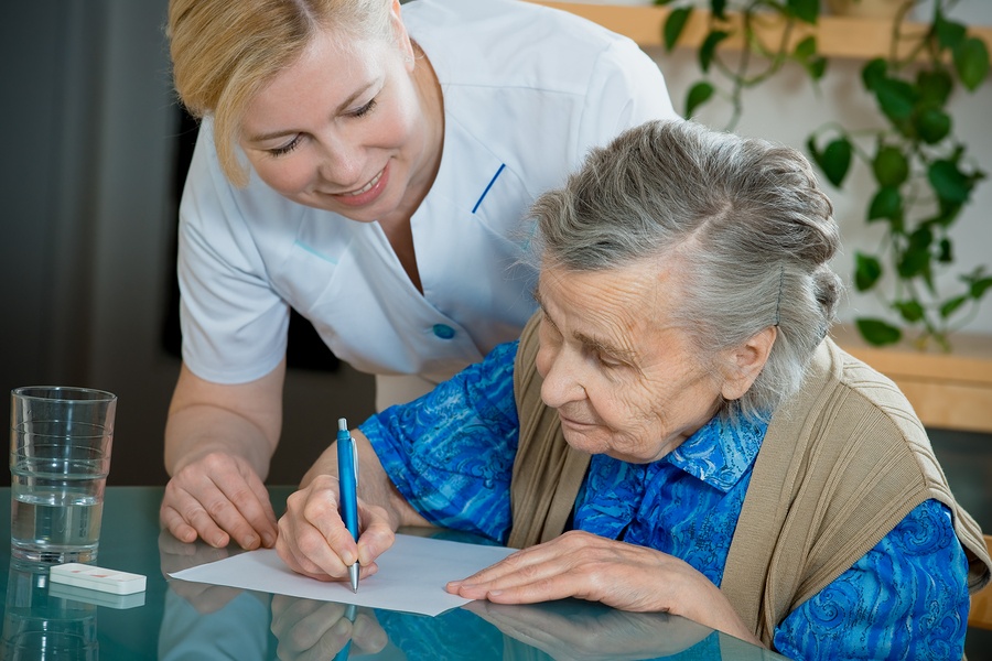 A caretaker fills out paperwork with her client