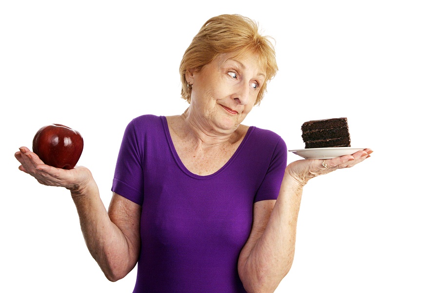 A woman holding cake in one hand and an apple in the other
