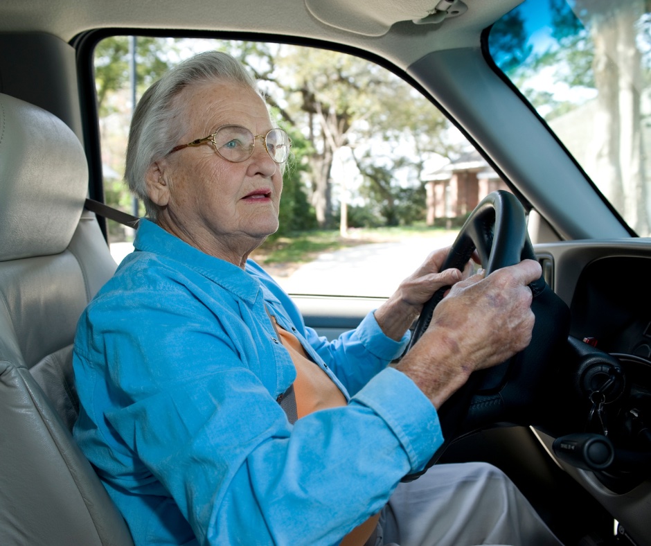 Female older woman driving car in neighborhood.