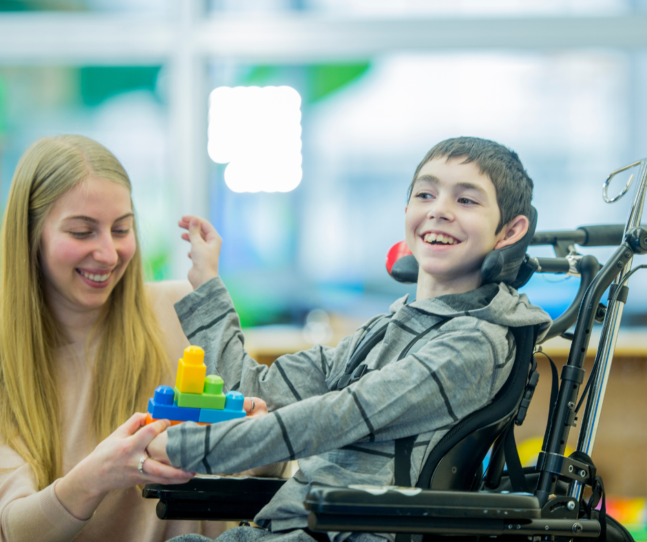 Caretaker playing with a child that has cerebral palsy