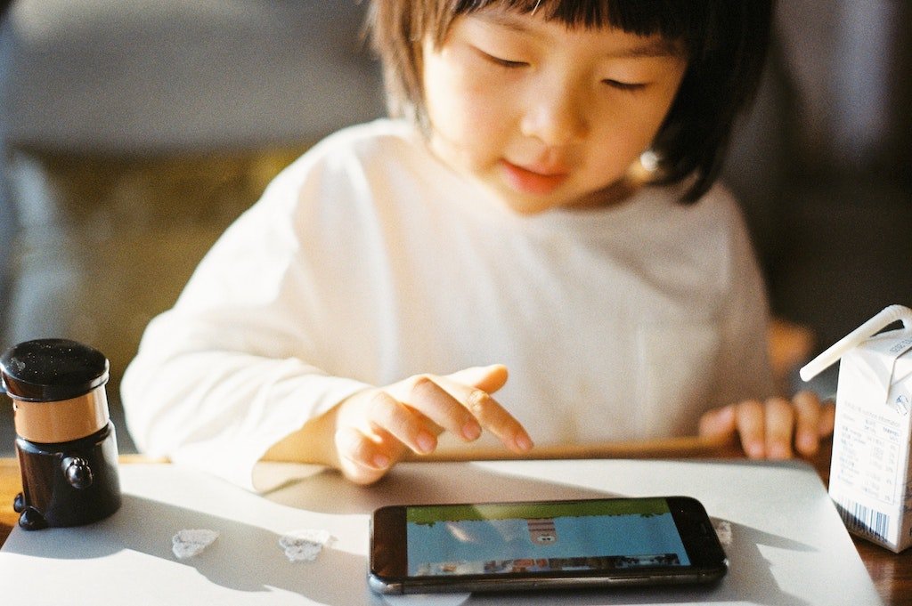 A child playing on their parent's smart phone