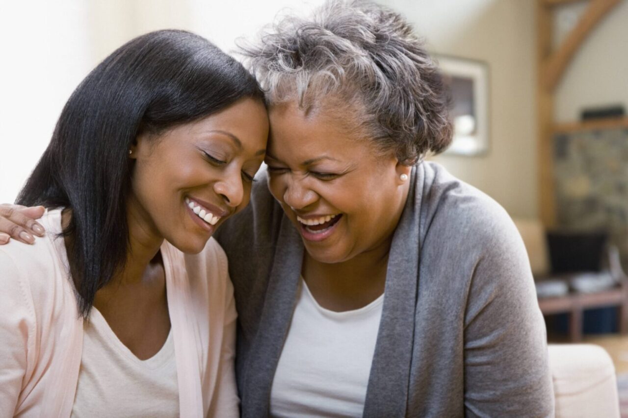 A woman and her adult daughter laughing together