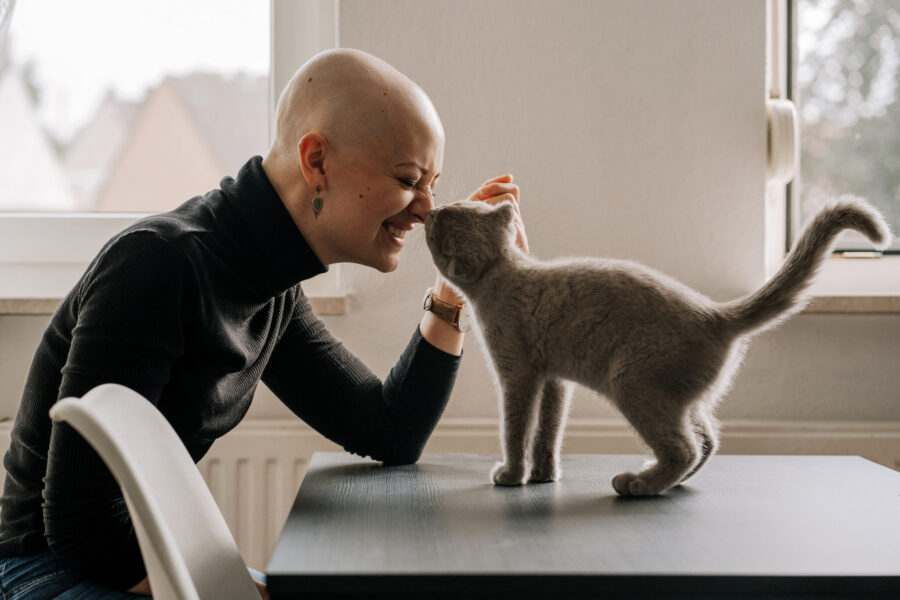 A woman fighting breast cancer plays with her cat