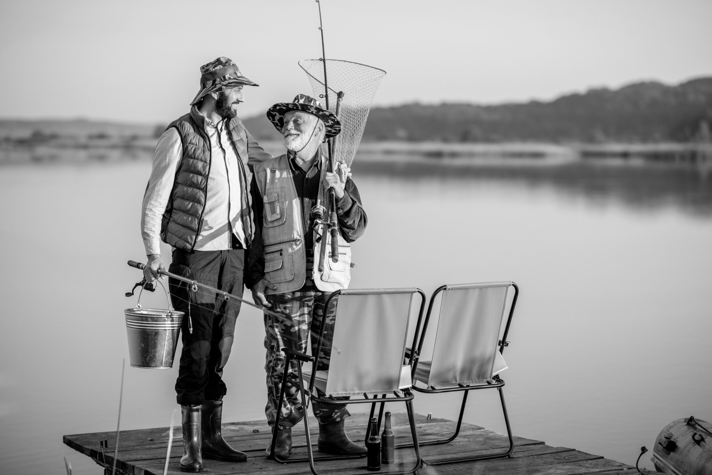 Grandfather with adult son fishing on the lake