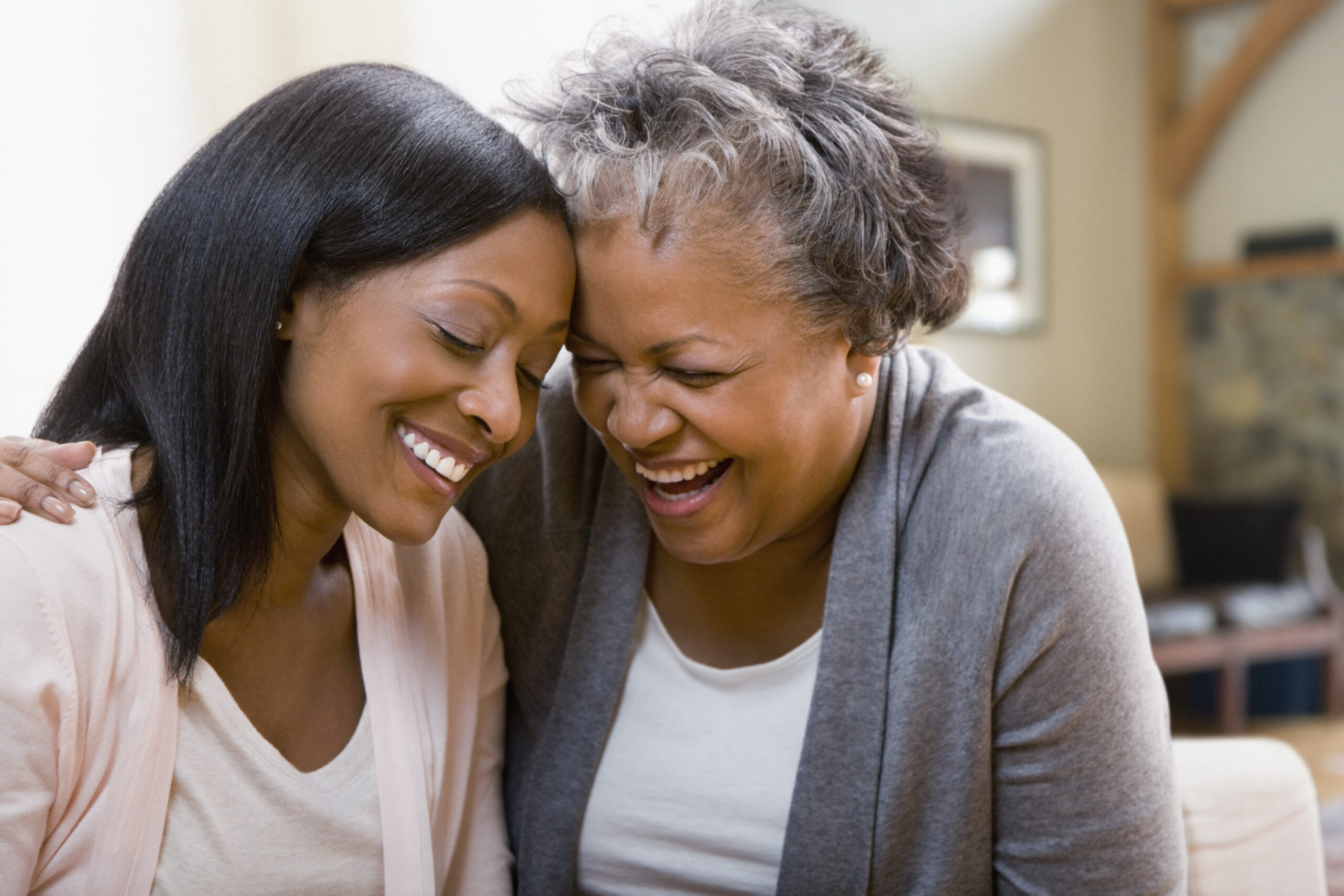 Elderly mother laughing with adult daughter