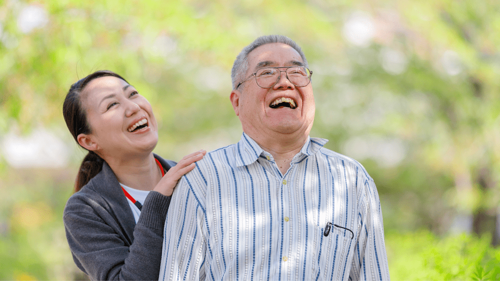 A woman and man laughing while outdoors