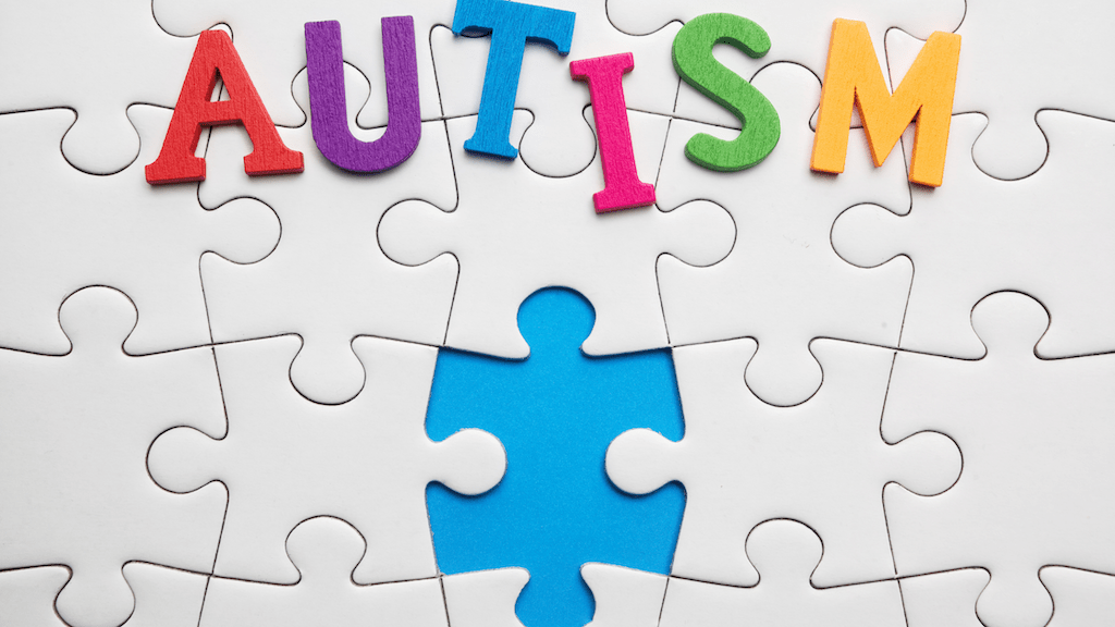 Autism spelled on a puzzle-piece background with one piece missing