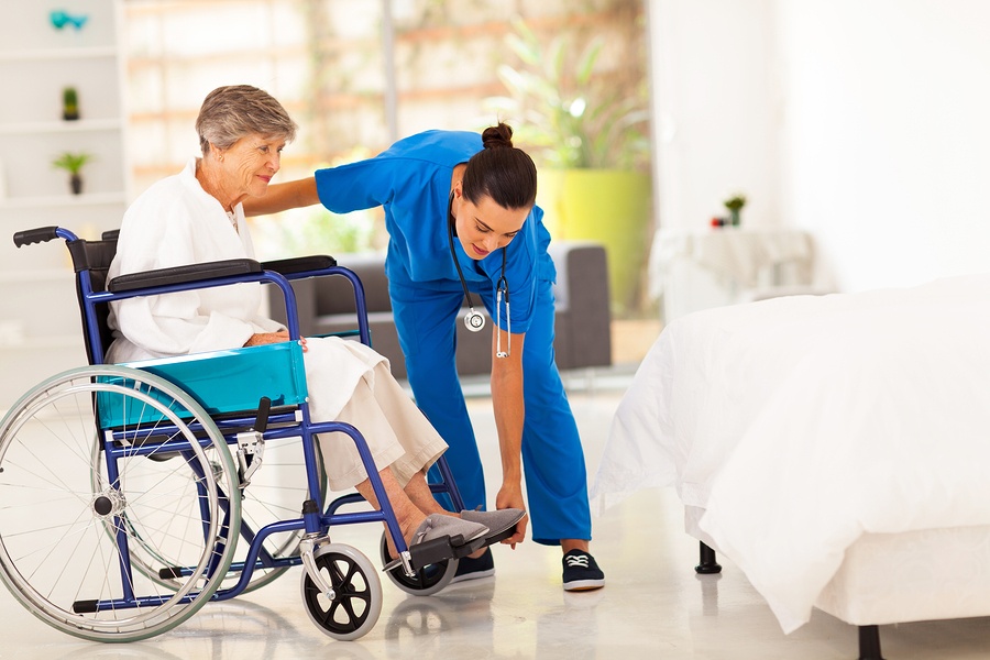 A caregiver helps her client with a wheelchair