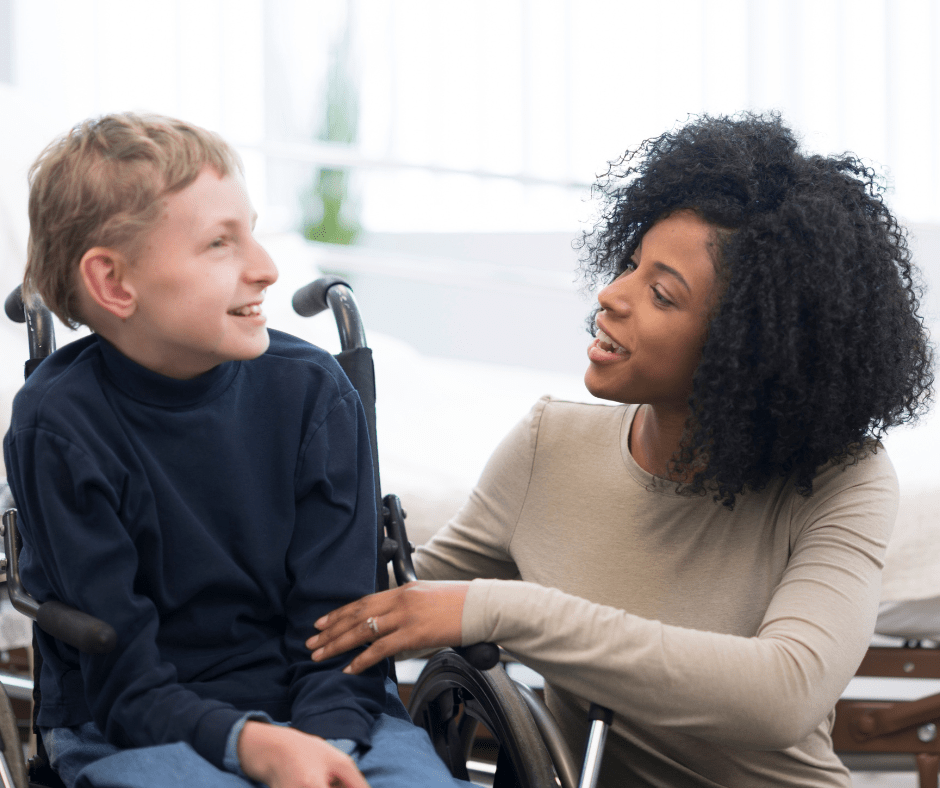 A caretaker helps boy with cerebral palsy