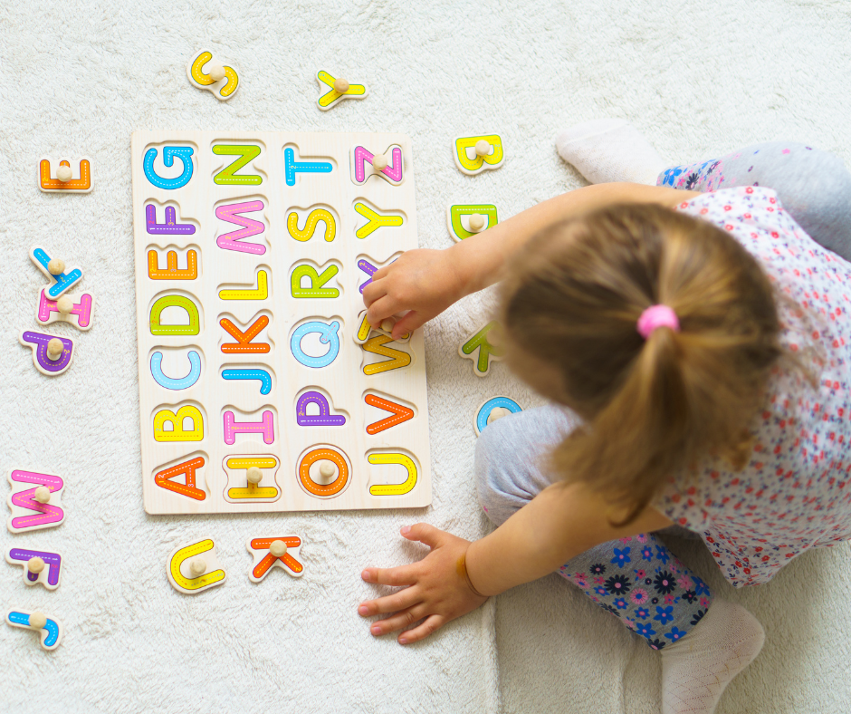 A young girl matches letters on a puzzle