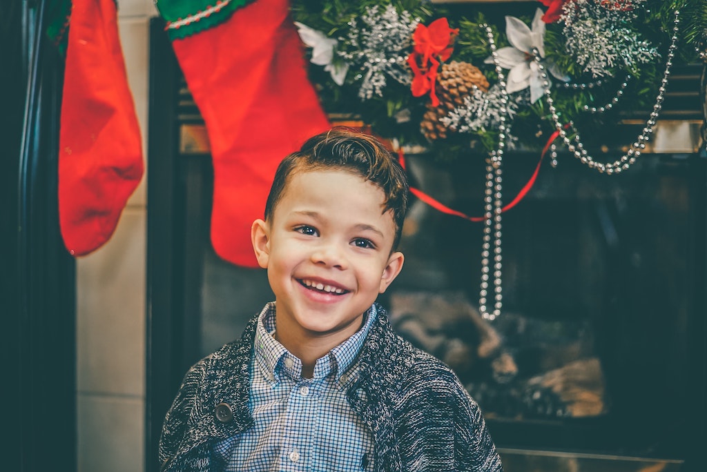 A boy smiling in front of Christmas decorations