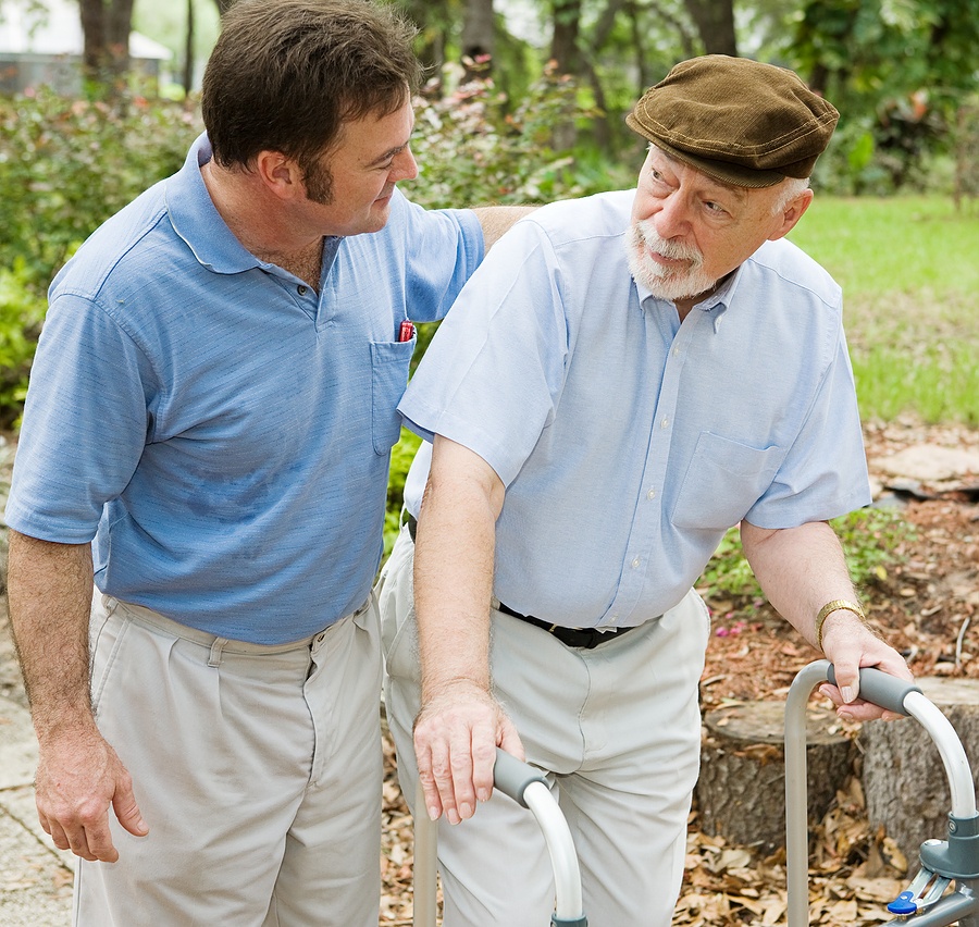 A senior father going for a walk with his adult son