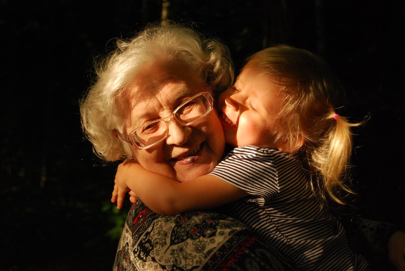 A grandmother embraces her granddaugher