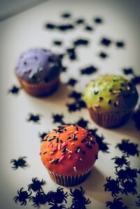 Halloween-themed cupcakes sprinkled with fake spiders.