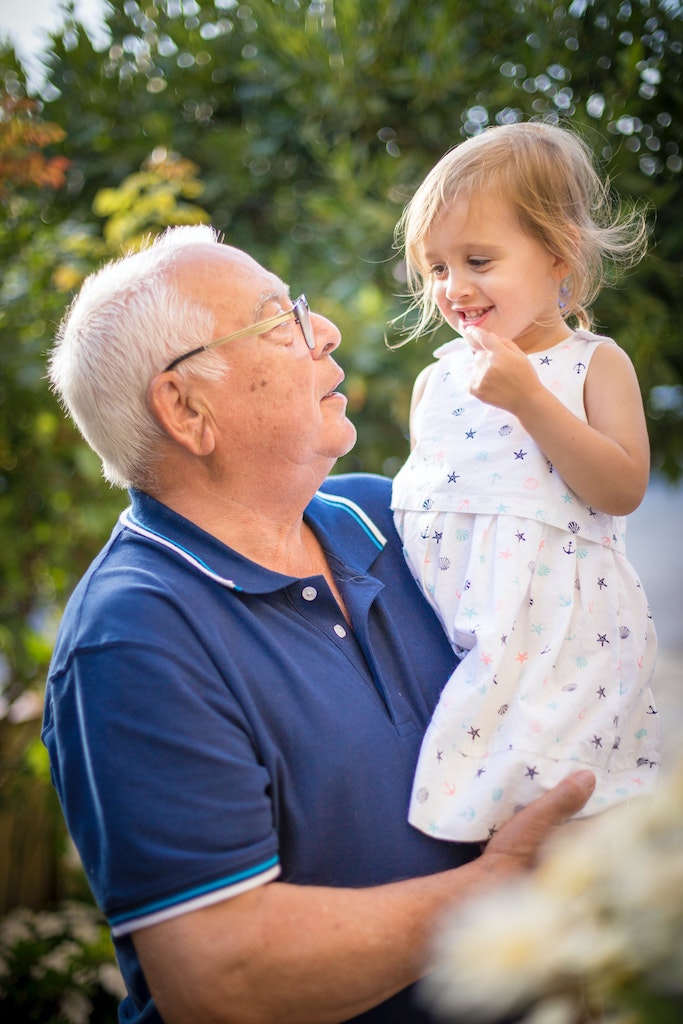 A grandpa carries his granddaughter