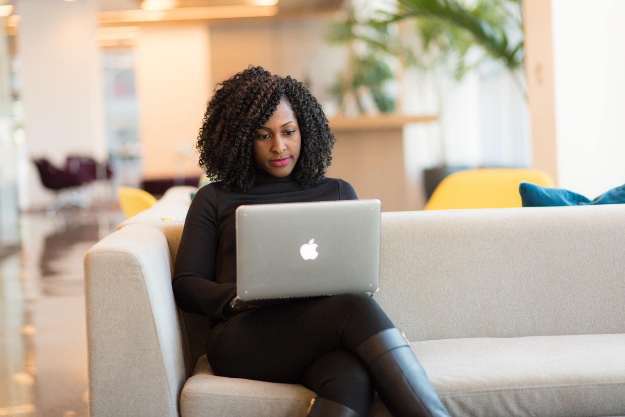 A woman uses her laptop on a couch