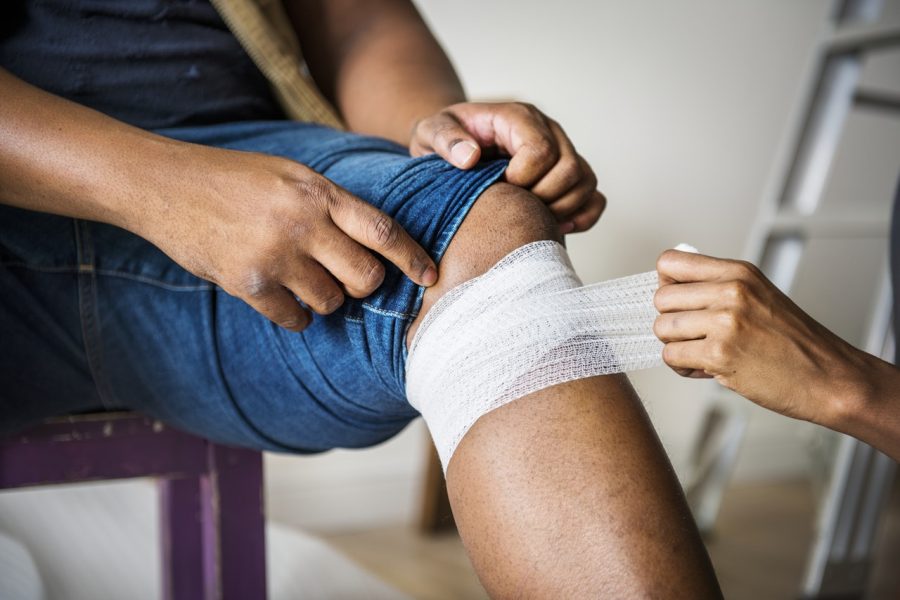 A bandage being applied to a knee