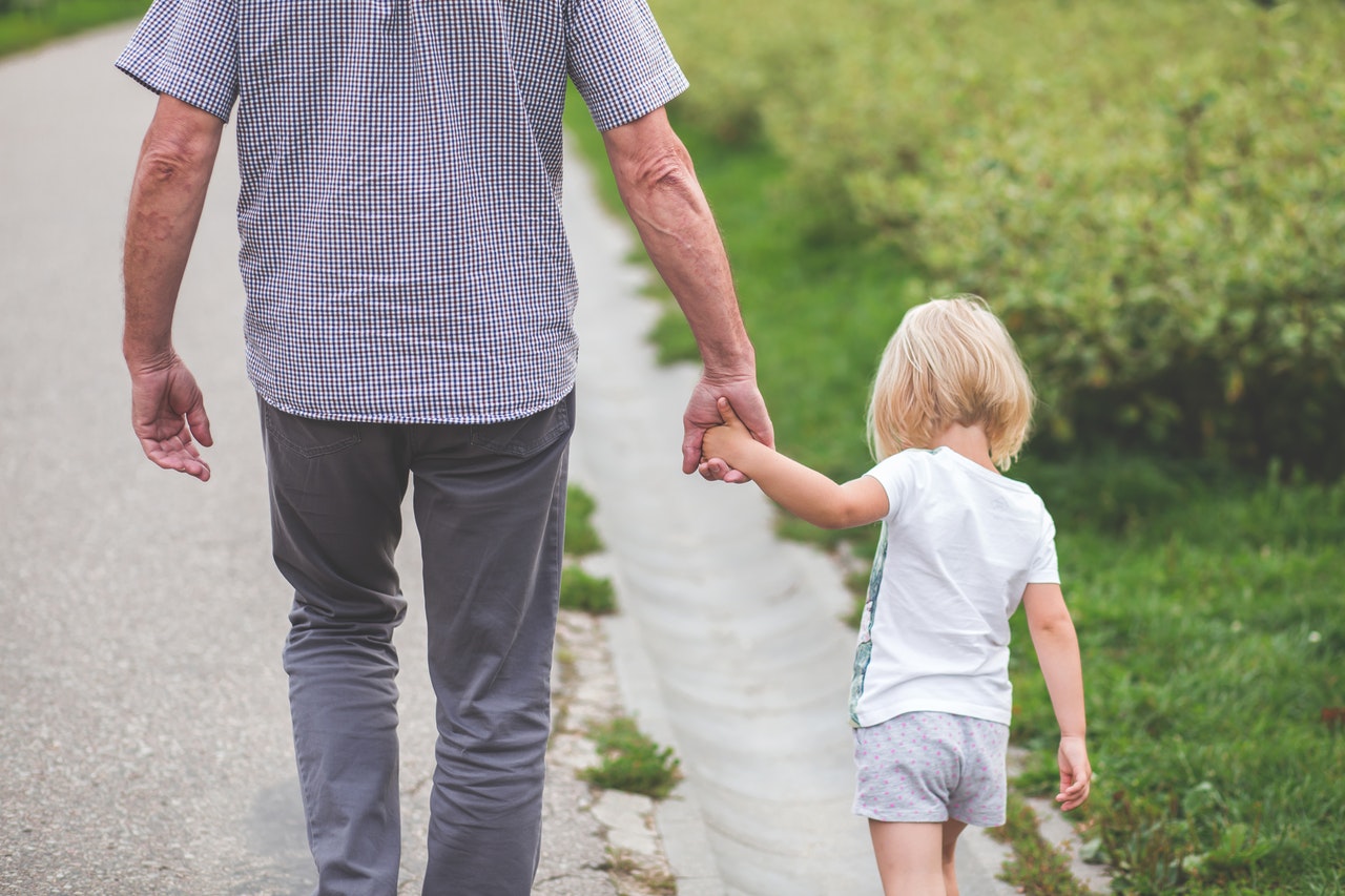 A grandpa going for a walk with his granddaughter