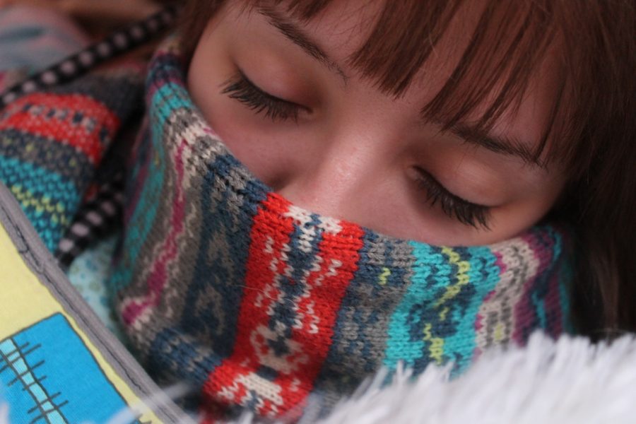 A woman's face wearing her scarf above her nose