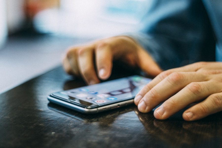 A person using their smartphone on a tabletop