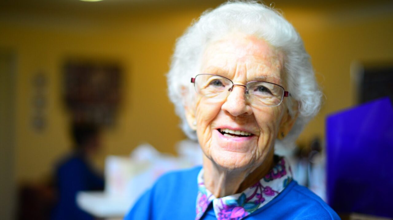 A senior woman smiles at the camera