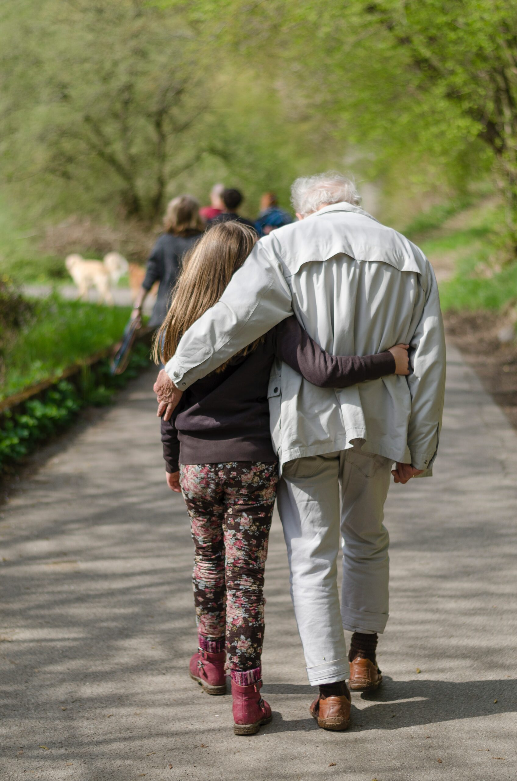 Elderly man walking with grandchild.