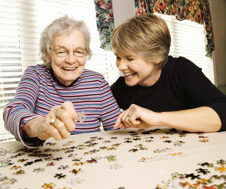 dementia patient with caregiver doing a puzzle