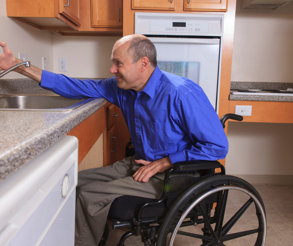 Man with disability in blue shirt using his accessible countertops and sink