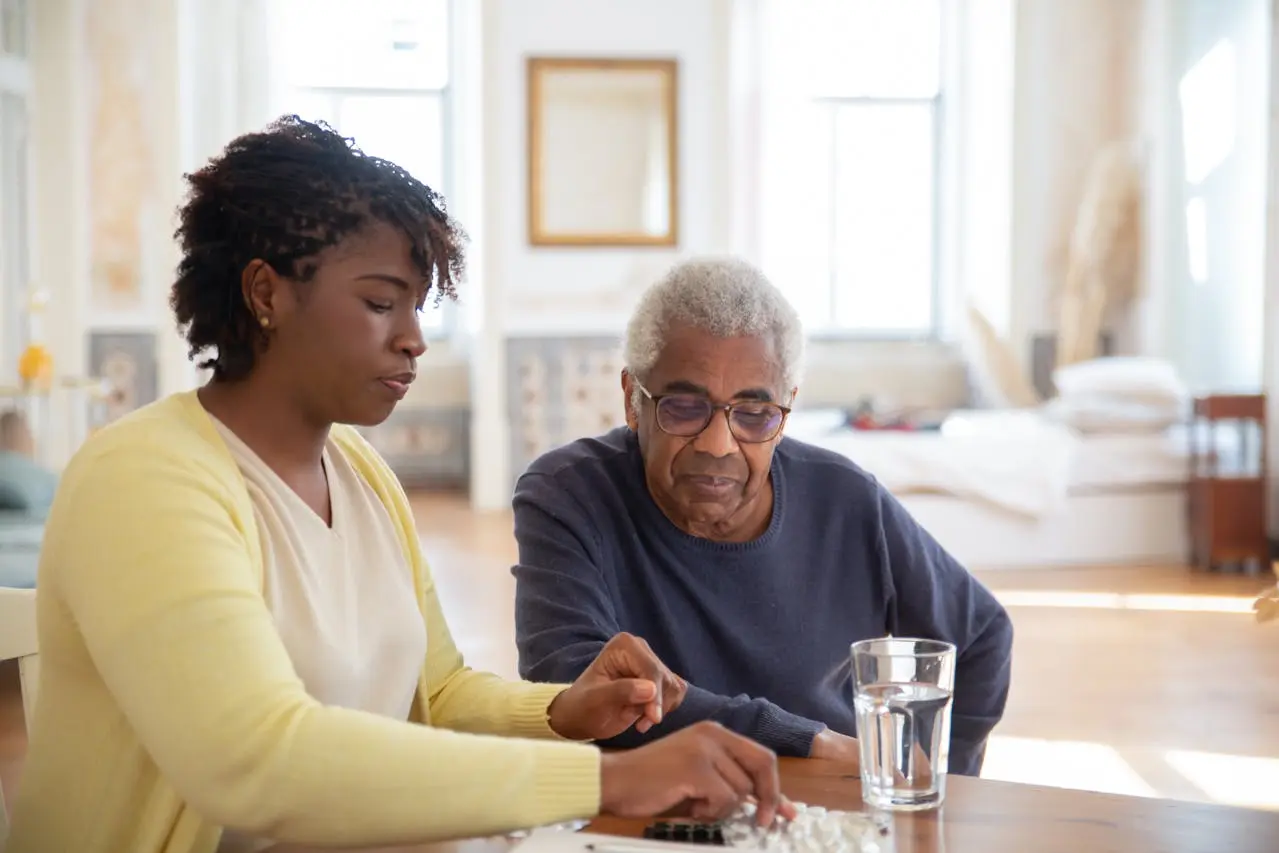 woman helping an older man with medication