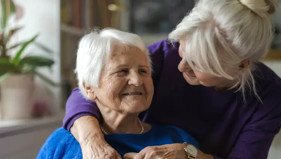 middle age woman hugging an elderly woman